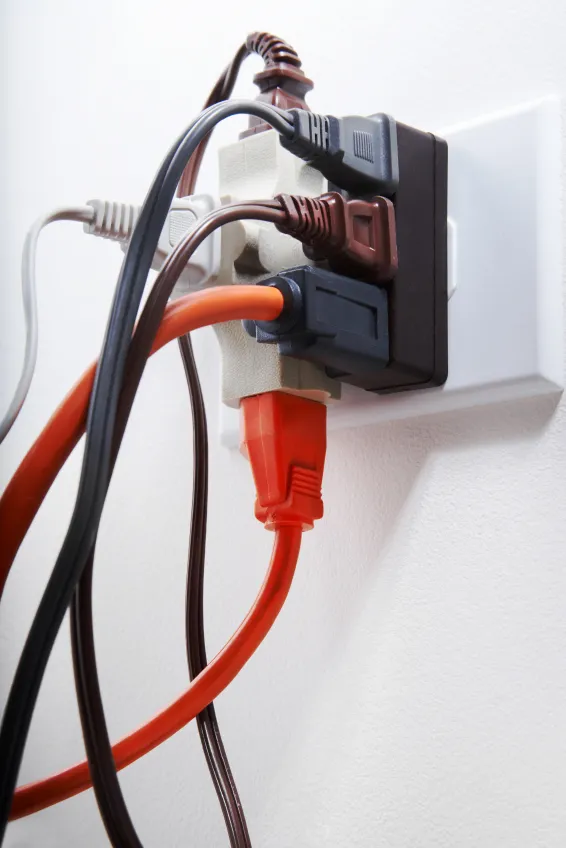 Overloaded electrical outlet with too many cords plugged in
